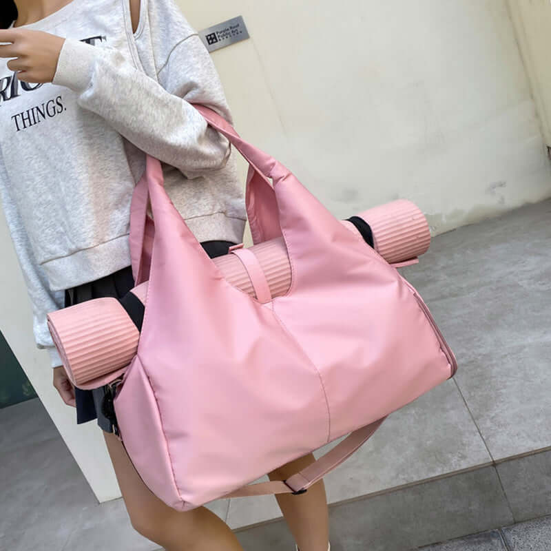 Woman carrying a pink Womens Yoga Bag with yoga mats, showcasing its stylish and functional design.