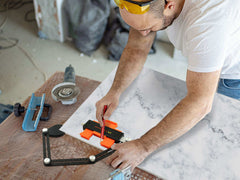 Person using the 10 & 5 Contour Gauge Set with Lock to measure and cut materials on a work surface.