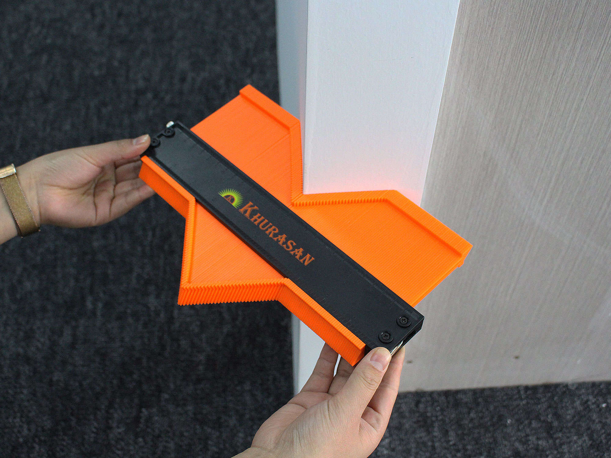 Hand holding contour gauge against corner profile to demonstrate shape copying